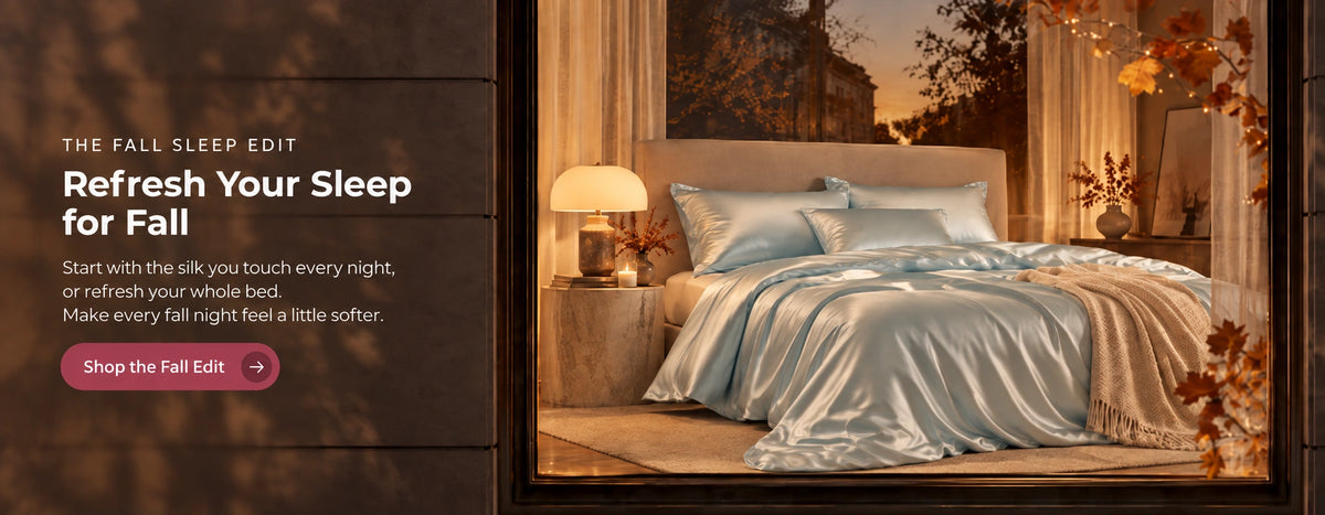 Blue silk bedding in a warm autumn bedroom seen through a window, with the message Refresh Your Sleep for Fall and a Shop the Fall Edit button.