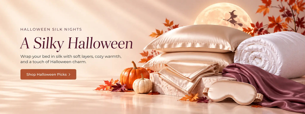 Luxurious champagne silk bedding, silk comforter, and silk sleep mask surrounded by autumn pumpkins and leaves, with a little witch flying across a glowing full moon in a cozy Halloween setting.